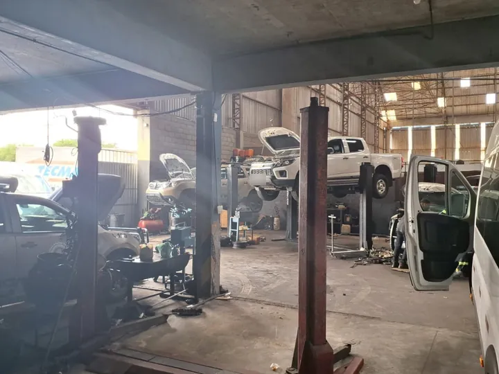 Galpão de serviços da Norte Diesel com caminhonetes nos elevadores